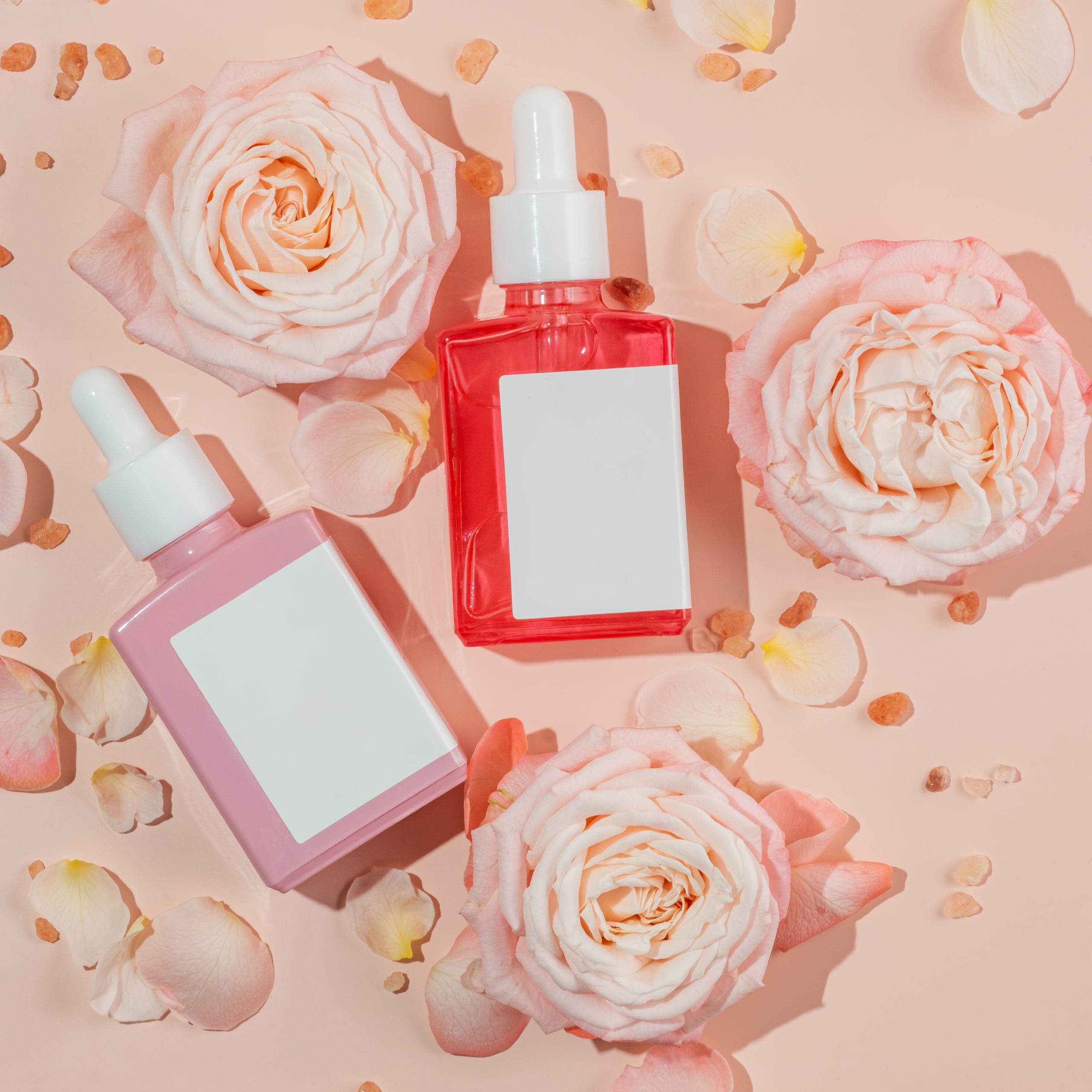 Two cosmetic bottle with pipette on pink background with rose flowers and petals, product packaging, anti aging serum with peptides, cosmetics mockup, spa concept